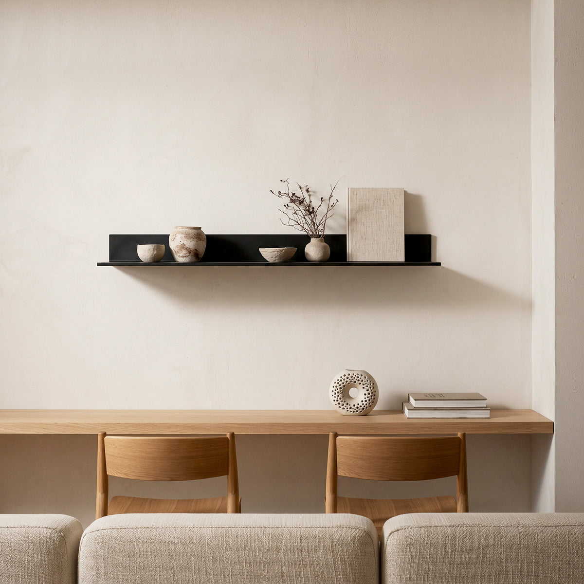 Aluminum wall mounted floating display shelf with concealed mounting on a beige wall, styled with ceramic vases